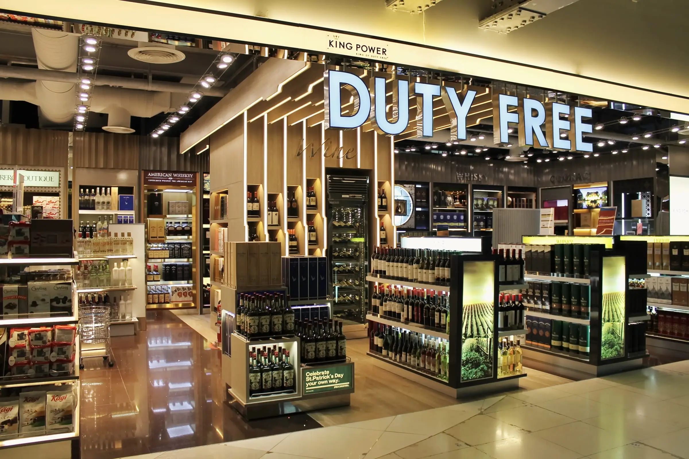 Duty-free retail floor with illuminated signage and stocked shelving